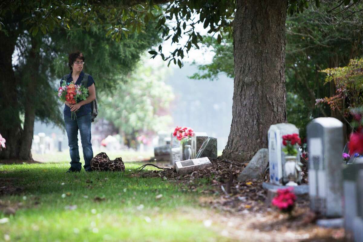 Amy Beebe, 24, looks for her brother's grave in Cleveland. ﻿Joseph Beebe was 8 ﻿when he died and like Amy and their sibling Jacob, as well as another child, had been abused by their adoptive mother in a home in Liberty County. Amy testifed during Edith Beebe's sentencing, before a judge gave the woman a 75-year term. ﻿﻿