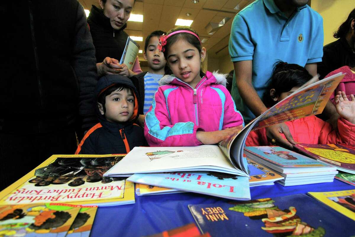 Krisha Parmar, 7 of Stamford, picks out one of three books each child would receive for participating in the Stamford Public Education Foundation bi-annual Reading is Fundamental Book Give-A-Way at the Ferguson Library in Stamford on April 2, 2016.