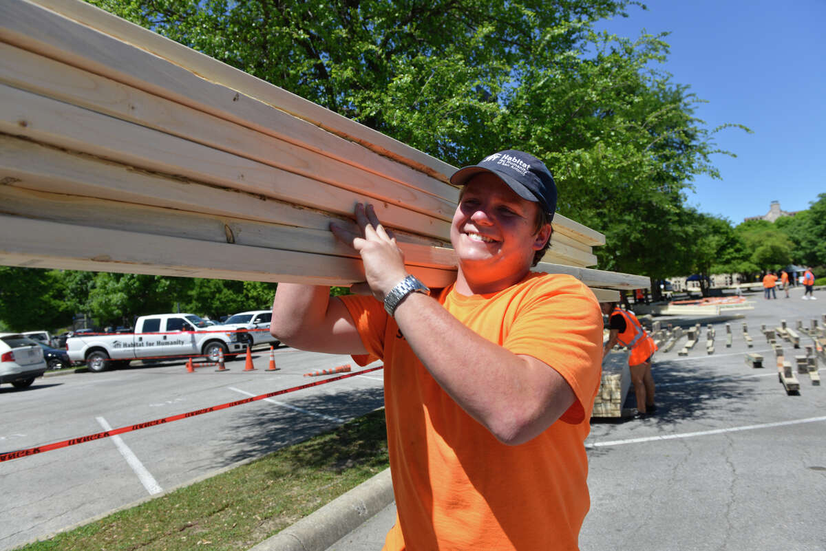 Matthew VanIOrman (cq) of Habitat for Humanity carries framing boards during a Project 240 event to build framing for 5 homes with volunteers from First Presbyterian Church Sunday in the church parking lot.