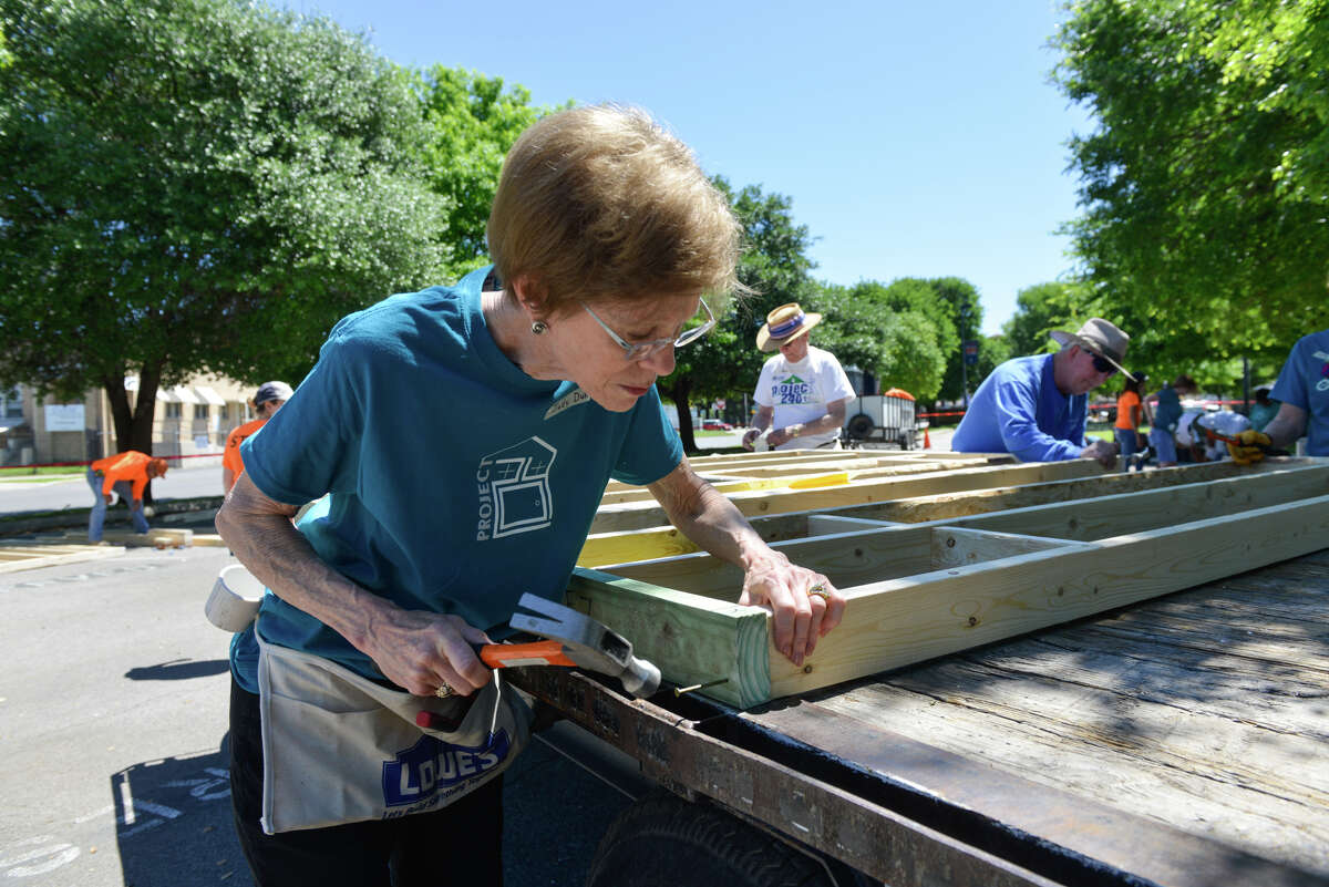 Judy Duke from First Presbyterian Church inspects a corner while building frames for Habitat For Humanity homes Sunday in the church parking lot downtown,