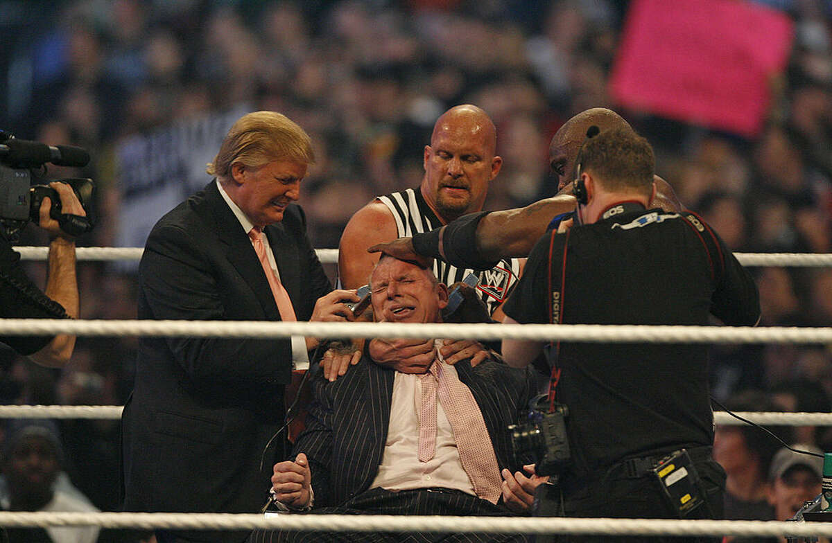 Vince McMahon gets his head shaved by Stone Cold Steve Austin as Donald Trump looks on at WrestleMania 23 at Detroit's Ford Field.