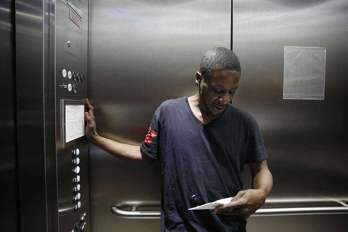 Vernon Mandigo, Franciscan Towers tenant who is formerly homeless, looks over mail in the elevator at the Franciscan Towers on Monday, April 4, 2016 in San Francisco, California.