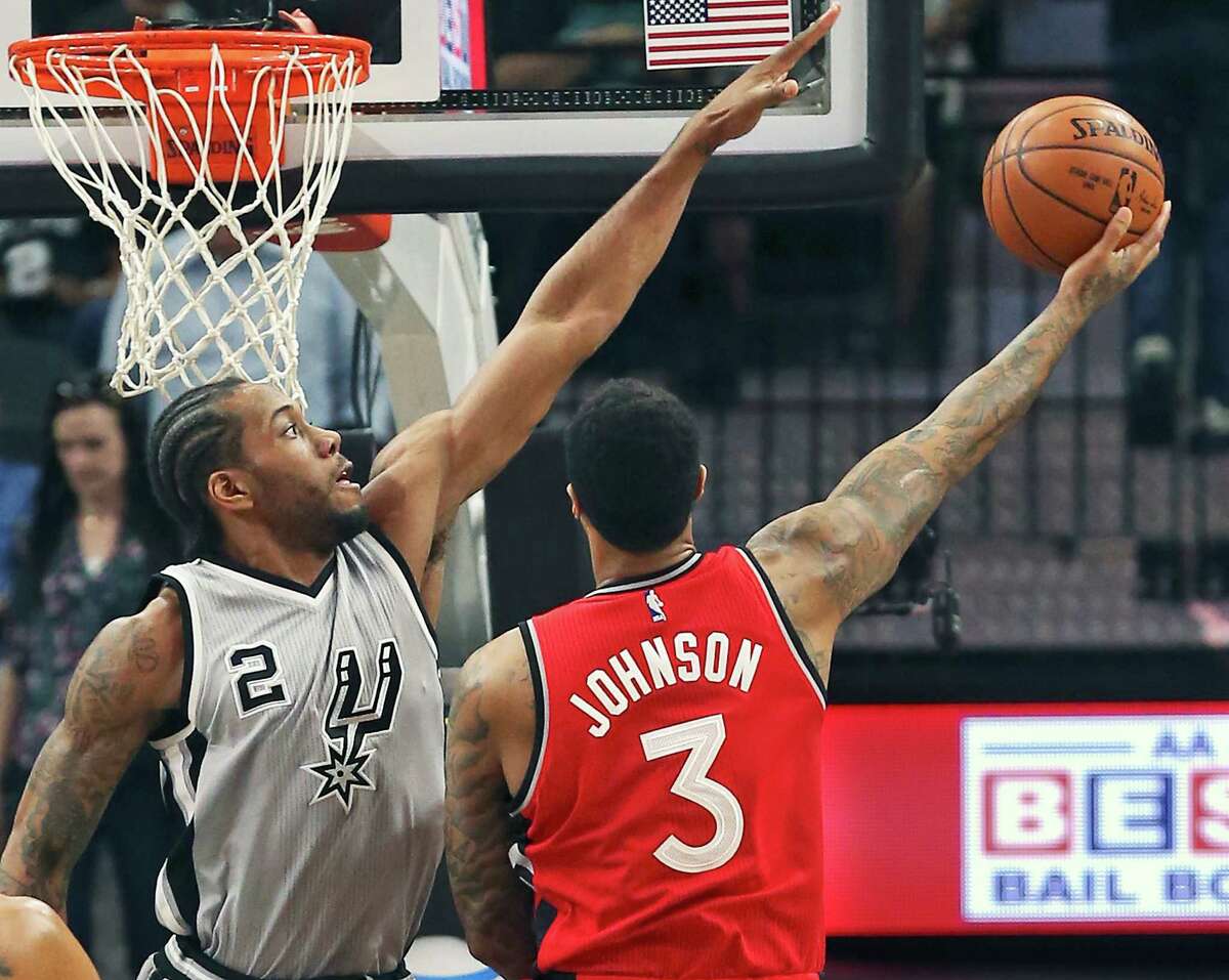Kawhi Leoanard stretches out defending against James Johnson as the Spurs play Toronto at the AT&T Center on April 2, 2016.