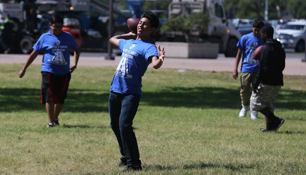 Michael Sanchez,14, (center) a student at Scobee Middle School, throws a football Monday April 4, 2016 at U.T.S.A. during the inaugural Southwest I.S.D. Career Exploration Day. About 1,000 eighth grade students from the district's three middle schools learned about trades, professions and different career paths from more than one hundred individuals. Industries represented at the event included arts and humanities, public service, science and technology and more. Students attending were also able to learn about the U.T.S.A. campus and other local San Antonio colleges that they can attend to start their career path.