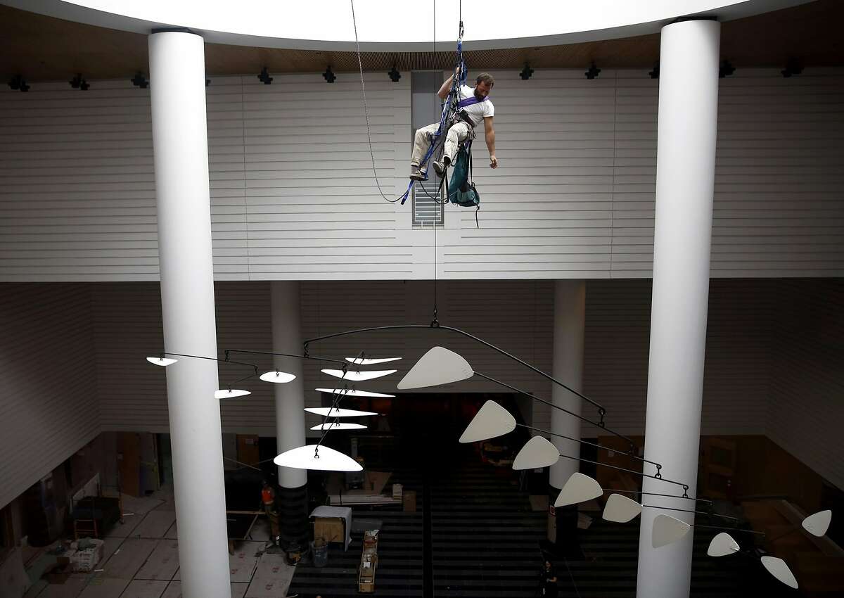 Lawrence LaBianca climbs back up to the top of the museum after repelling down to finish the installation of an Alexander Calder mobile at the Museum of Modern Art in San Francisco, California, on Tuesday, April 5, 2016.