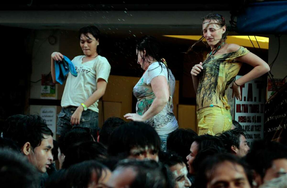 BANGKOK, THAILAND - APRIL 13: Tourists and Thai people celebrate on the first of three days of Songkran New Year festival, amid the political turmoil of weeks of protests and more recently, clashes with the Thai military, at Khao Sarn Road on April 13, 2010 in Bangkok, Thailand. Thailand's foreign minister Kasit Piromya ruled out any immediate role for ousted former Prime Minister Thaksin Shinawatra at a global nuclear summit in Washington last night, with US Secretary of State Hillary Clinton urging Thailand to instead embrace reconciliation. (Photo by Luis Ascui/Getty Images)