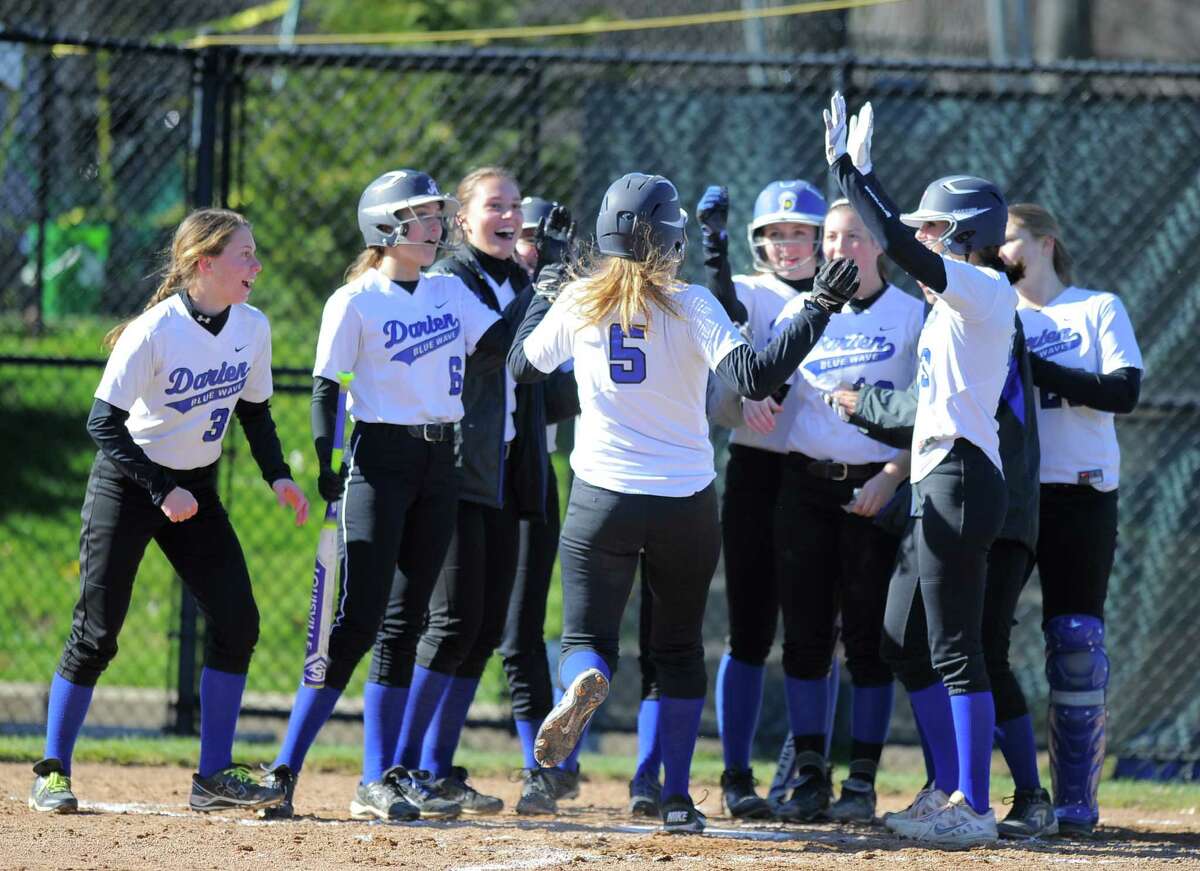 Darien’s Cassie Lopiano is greeted at homeplate by her teammates following a second-inning three-run home run in a 14-2 win over Danbury on Tuesday.