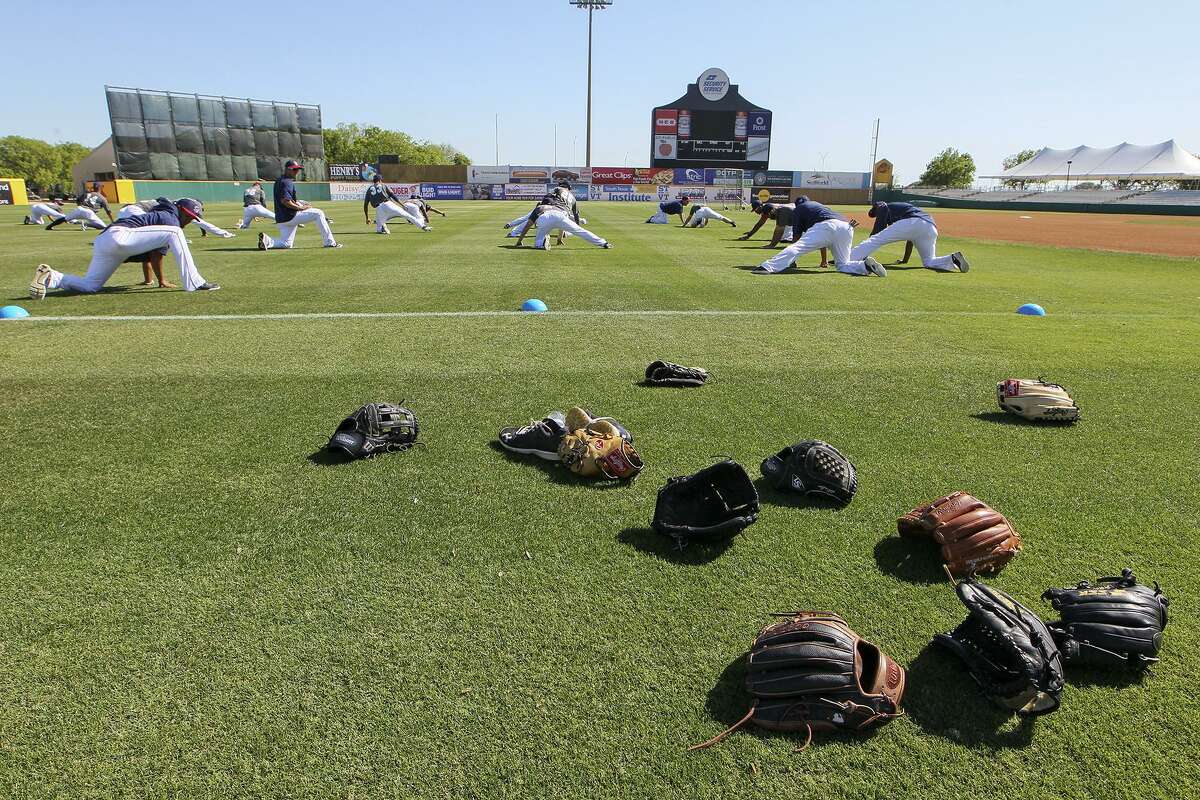 Players leave their gloves on the field as they stretch during the first day of practice for the San Antonio Missions at Wolff Stadium onApril 5, 2016.