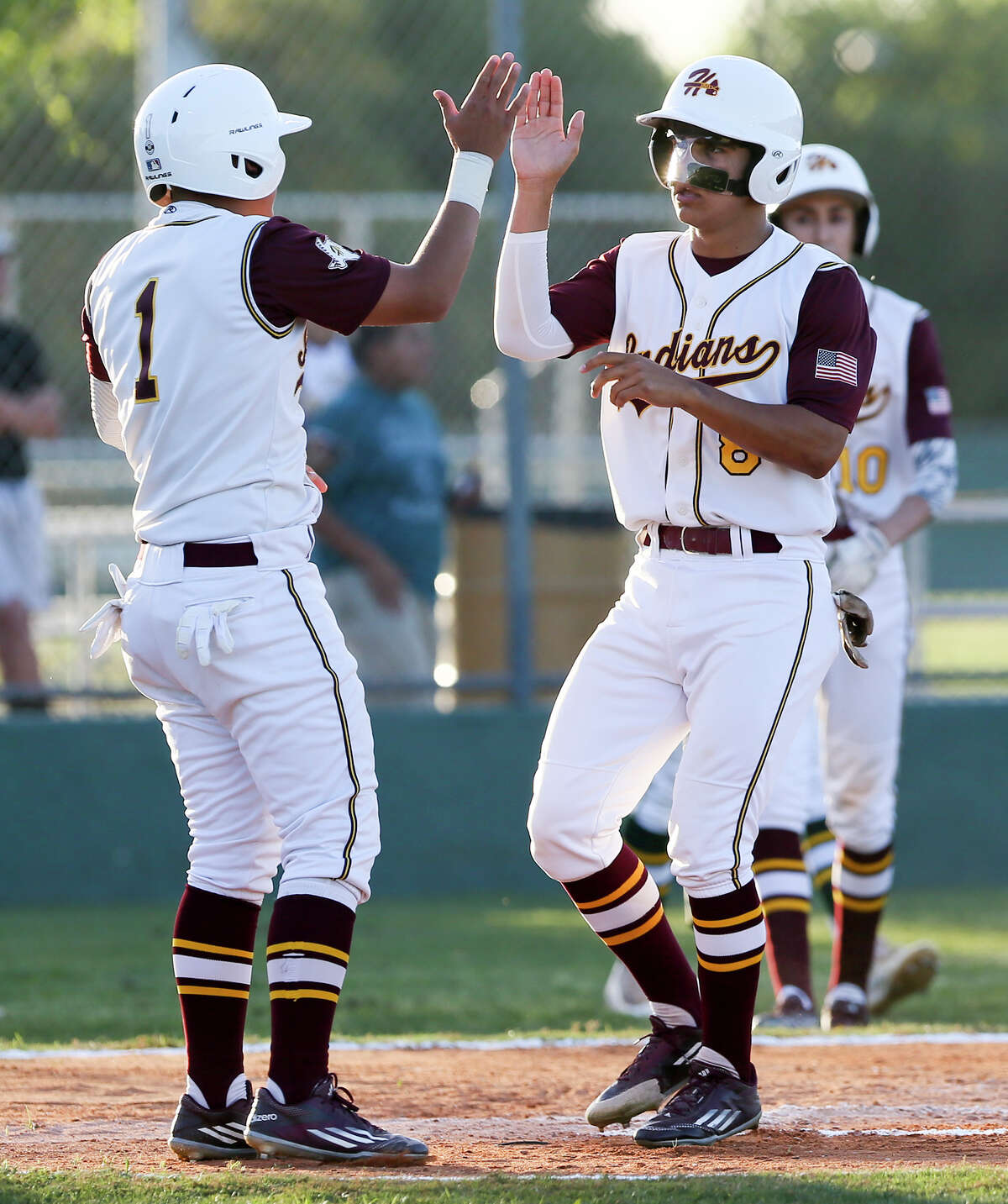 Harlandale’s Timothy Smith (left) congratu lates Shawn Tober after they scored in the first inning of their 8-2 win over District 28-5A rival McCollum on March 31. Harlandale, McCollum and Highlands were tied at first with 7-1 records through the first round of district play.
