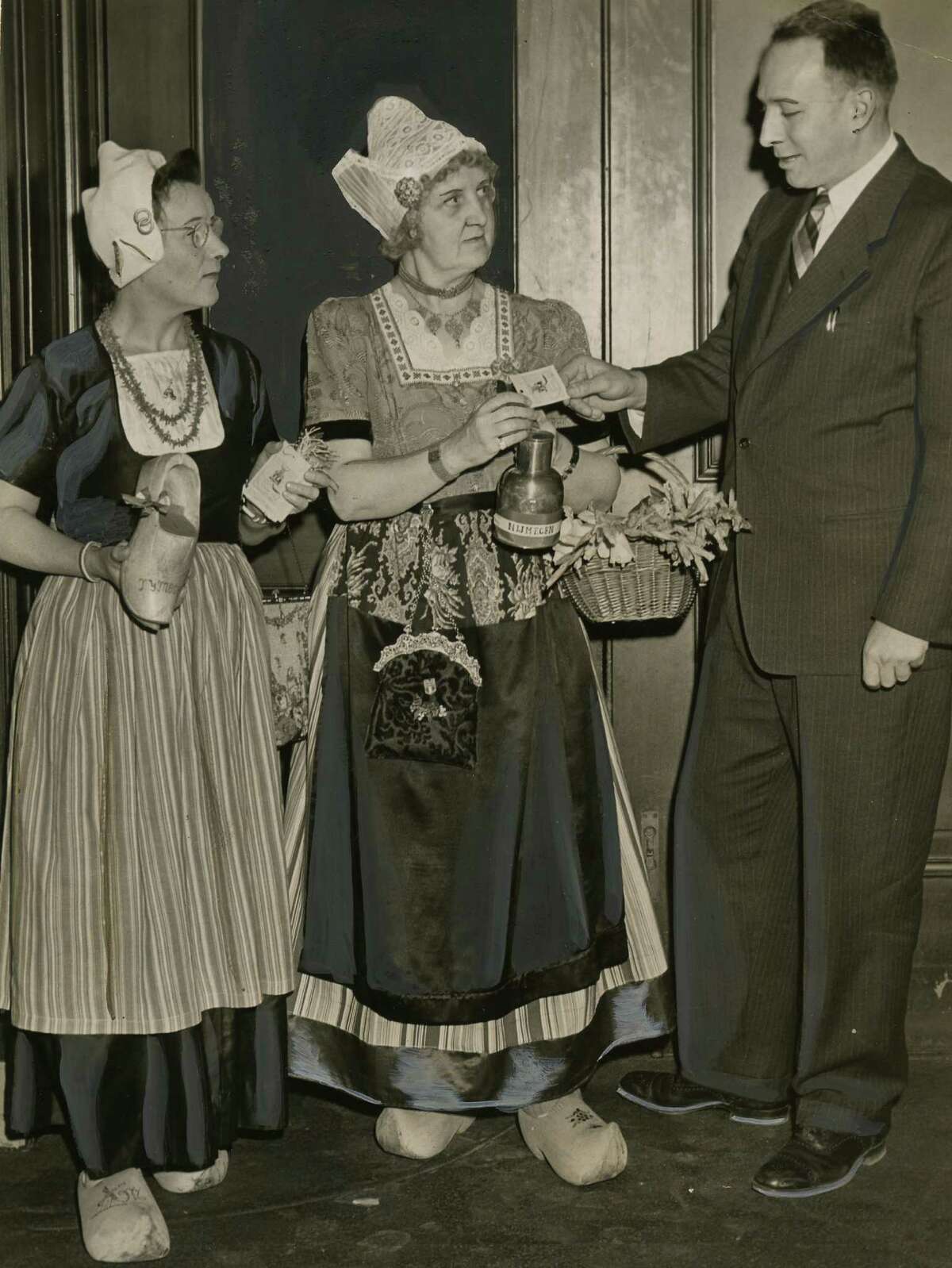 Mrs. Frank Spoor, left, and Mrs. John van Galen, center, sell a Nijmegen campaign tag to Mayor Erastus Corning, right, at City Hall in Albany April 16, 1947. (Times Union archive photo)