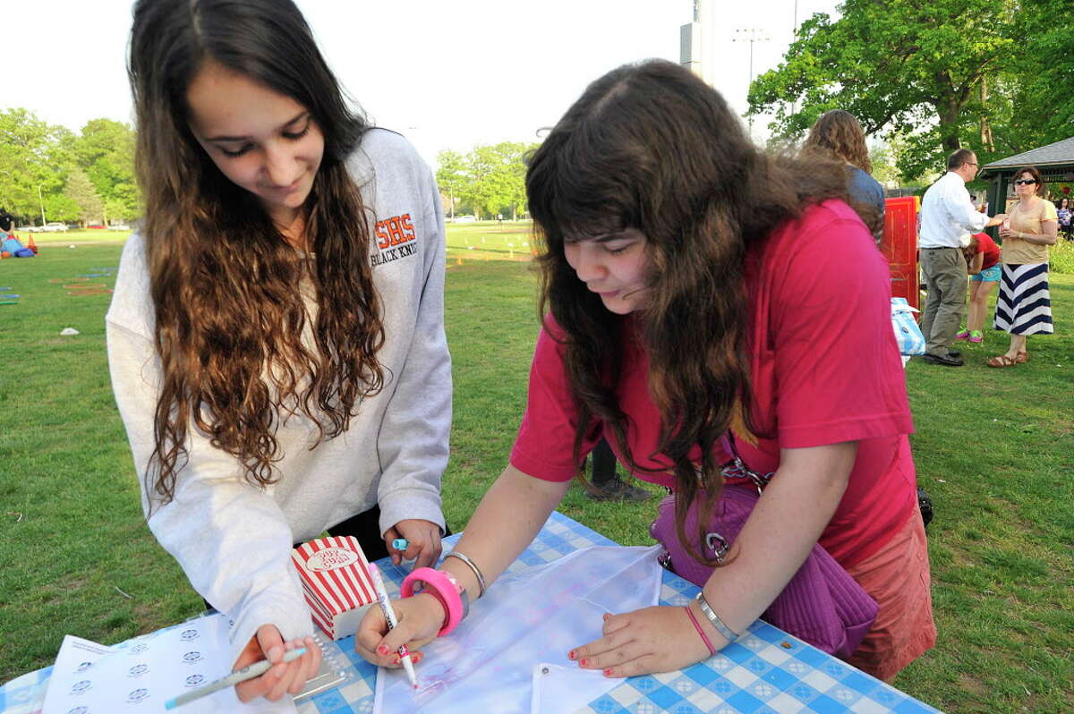 Volunteer Marissa Young, left, helps Hilary Greenwald decorate a kite during the Friendship Circle's end-of-year barbecue at Scalzi Park in Stamford, Conn., on Tuesday, May 19, 2015. Friendship Circle is a non-profit organization that pairs volunteers with people with special needs. The organization works with volunteers help to offer a full range of social and Judaic programs.