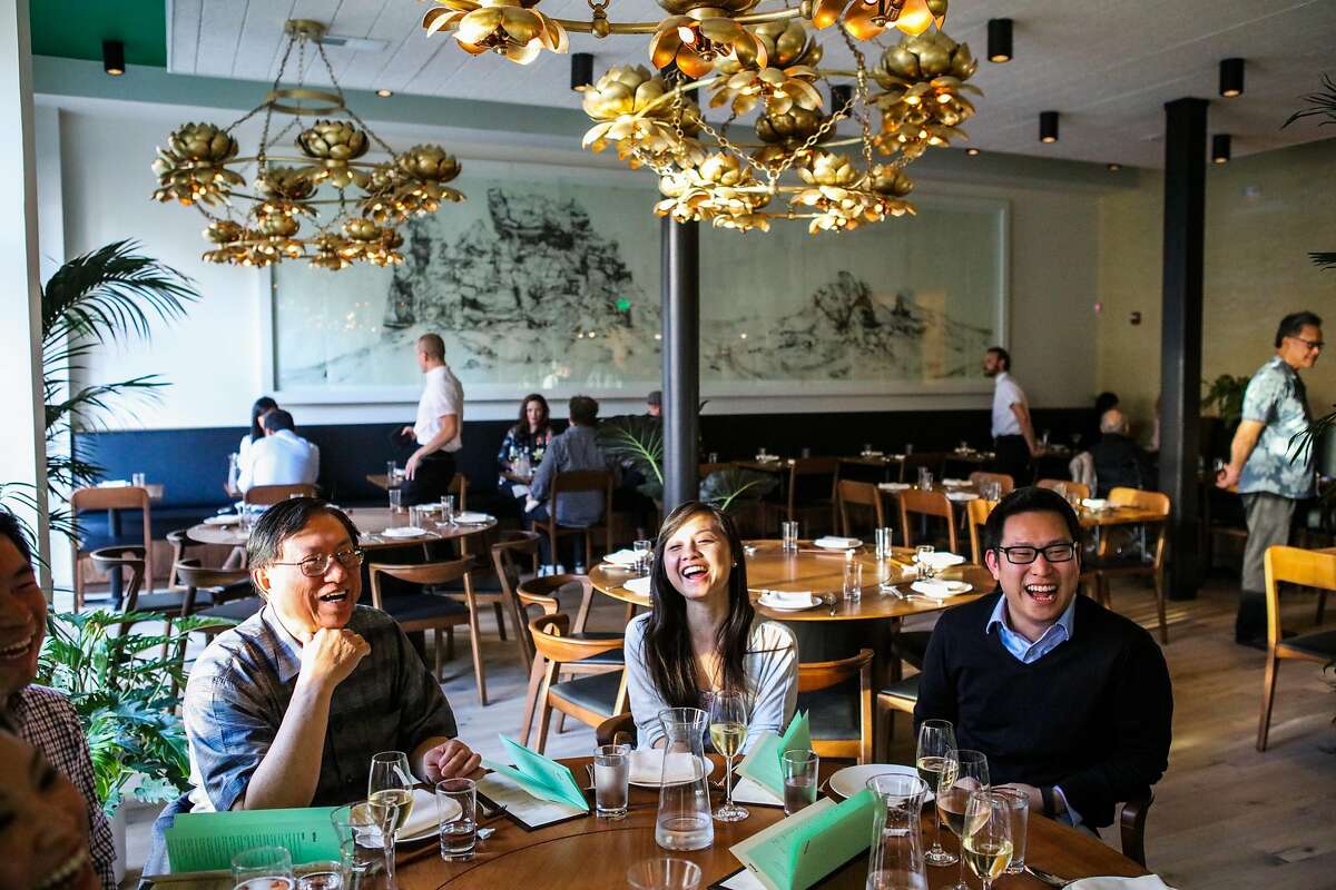 (l-r) Thomas Wong, Erika Lam and Brian Ko share a laugh as they dine at the friends and family preview of Mister Jiu's restaurant in San Francisco, California, on Wednesday, April 6, 2016.
