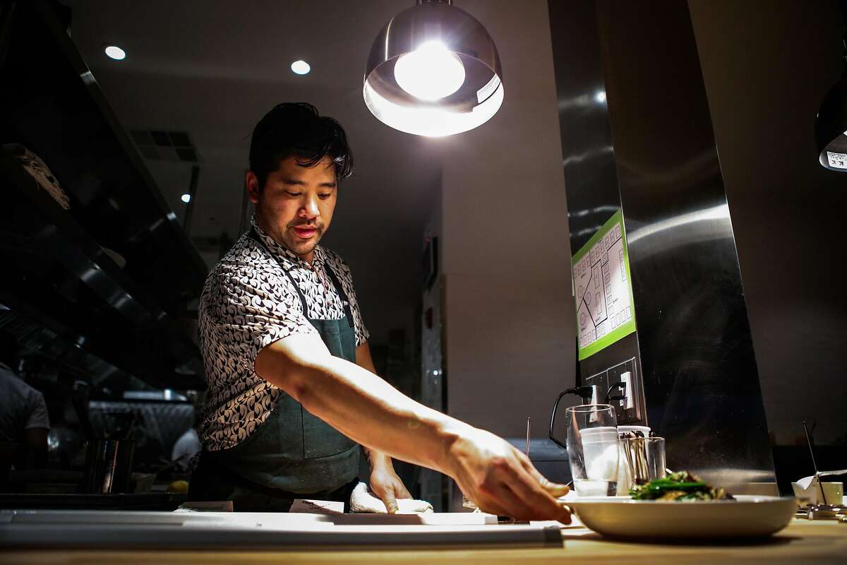 Chef Brandon Jew, sets down the smokes hood tofu, as it is ready to be served, at the soft opening of his restaurant Mister Jiu's, in San Francisco, California, on Wednesday, April 6, 2016.