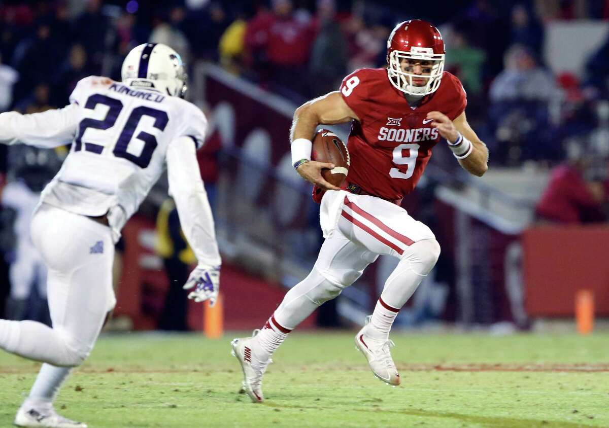Oklahoma quarterback Trevor Knight, a former Reagan star, runs as TCU safety Derrick Kindred, an ex-Wagner standout, closes in during the fourth quarter in Norman, Okla., on Nov. 21, 2015.