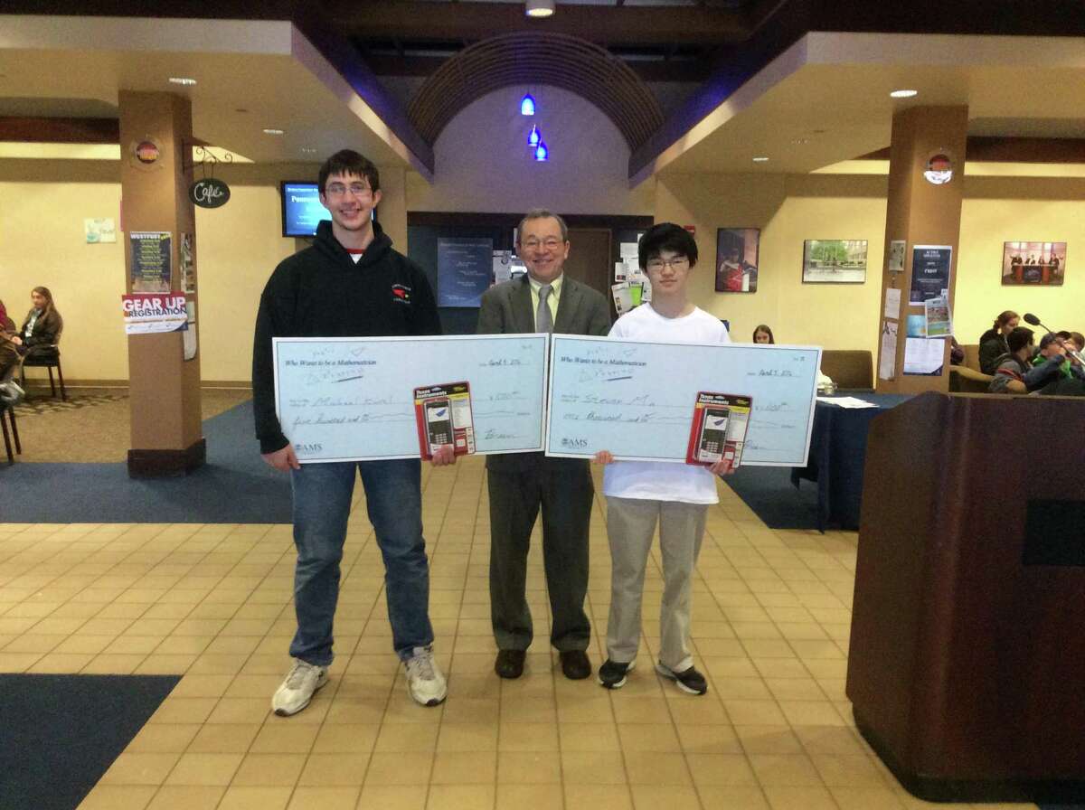 Greenwich High School senior Michael Kural, left, and Steven Ma stand alongside “Who Wants to Be a Mathematician” host Mike Breen with the checks they for their top finishes in the competition Tuesday, April 5, 2016 at Western Connecticut State University.