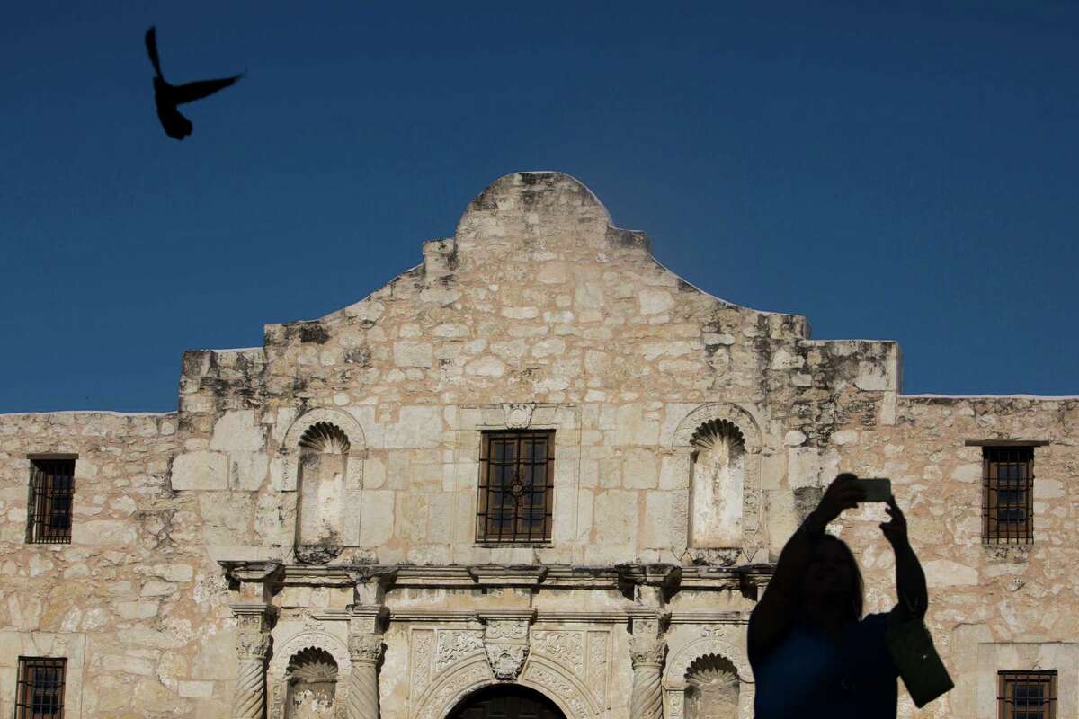 A tourist takes a selfie at the Alamo last year. A draft master plan for the shrine is in the works.