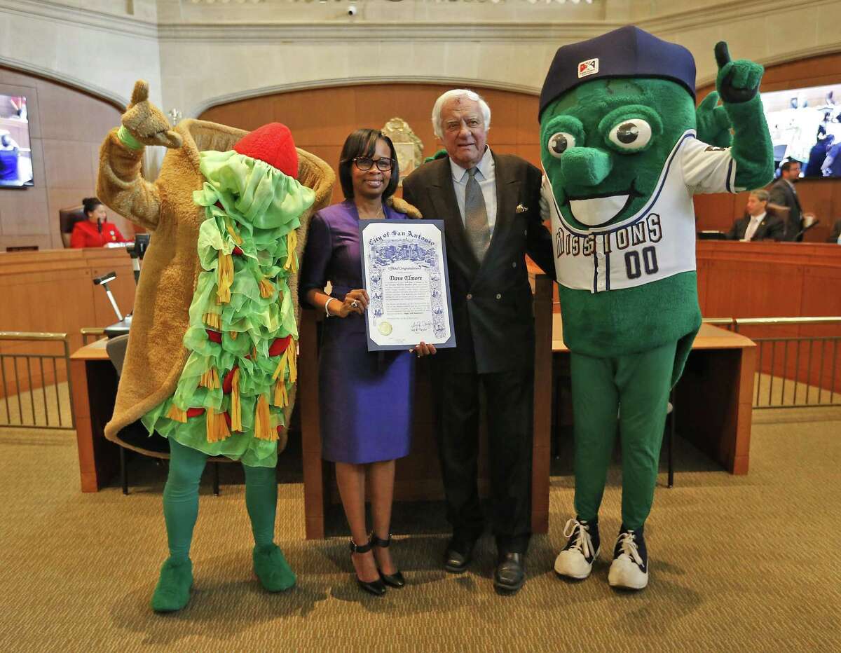 San Antonio Missions owner David Elmore (second from right) and Mayor Ivy Taylor — along with mascots The Puffy Taco (far left) and the Missions Ballapeno (far right) — pose for a photo as Taylor and Elmore announce at a City Council meeting that Triple-A baseball is headed to San Antonio for the 2019 season.