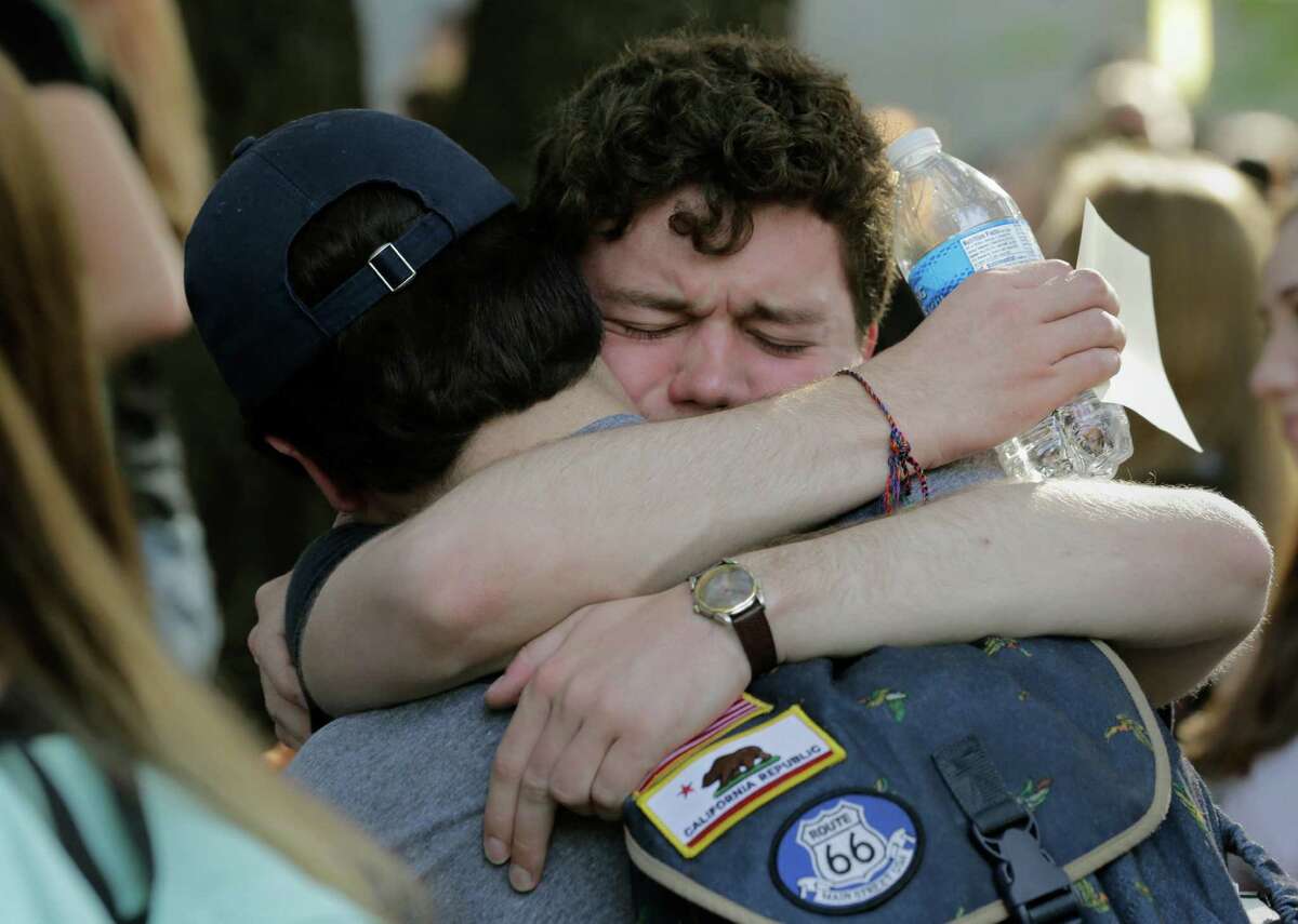 Texas students embrace during a gathering for fellow student Haruka Weiser on campus, Thursday, April 7, 2016, in Austin, Texas. Weiser, 18, a first-year dance student from Oregon, was last seen leaving a university drama building Sunday night. Her body was discovered in a creek in the heart of the university's Austin campus on Tuesday. (AP Photo/Eric Gay)