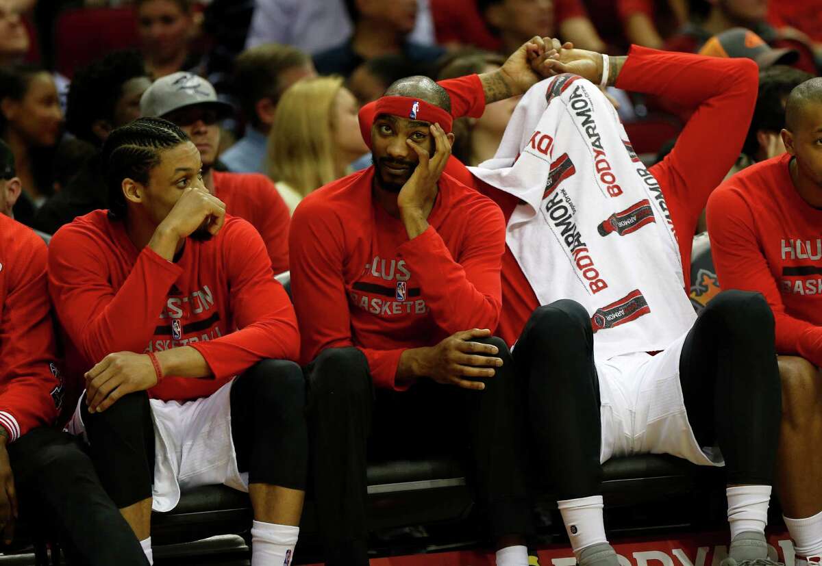 Houston Rockets guard K.J. McDaniels, Corey Brewer and Josh Smith, covering his head, react on the bench in the final minute during the second half of an NBA basketball game at Toyota Center, Thursday, April 7, 2016, in Houston. Rockets lost to Phoenix 124-115.