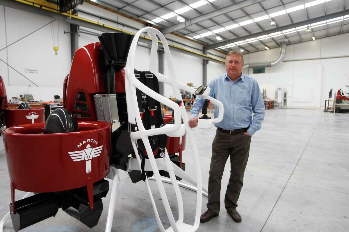 In this Feb. 9, 2016 photo, Martin Aircraft CEO Peter Coker stands next to a Martin Jetpack in Christchurch, New Zealand. The company says it?s close to commercial liftoff, but the man who started it fears his vision of a personal jetpack will remain grounded. (AP Photo/Nick Perry)