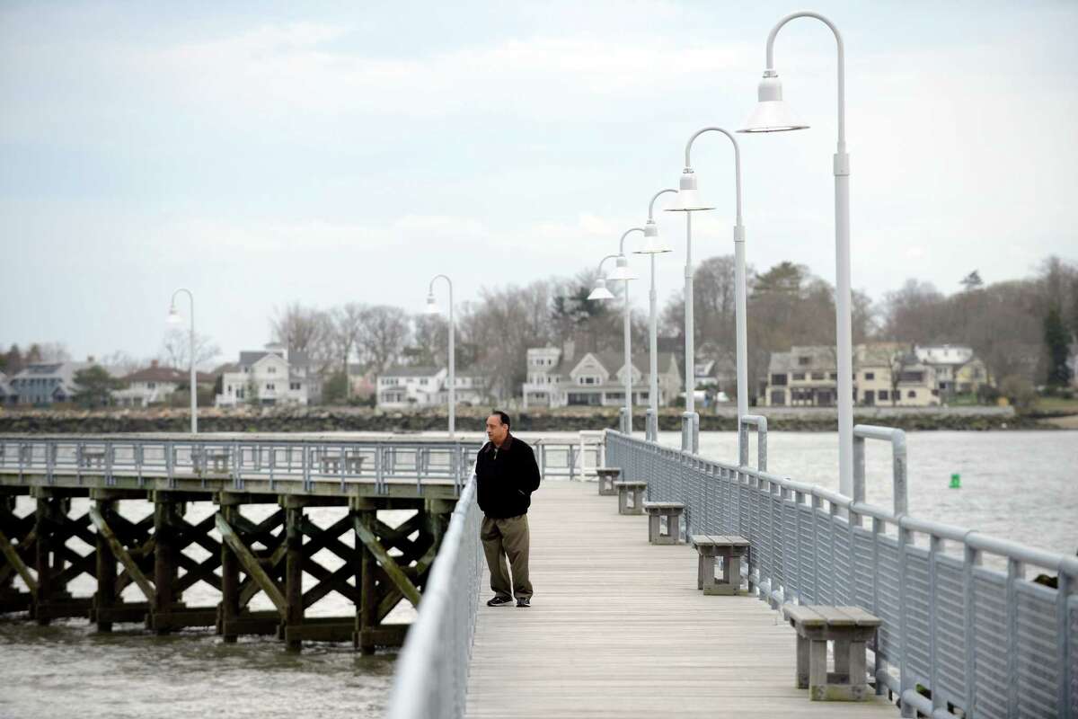 Sharma Arunbhai of Stamford takes his daily walk on the pier at Cummings Beach in Stamford on April 7, 2016. Arunbhai, who immigrated from India to the U.S., comes to the beach two or three times a week for exercise. Today he caught a break in the rainy weather and enjoy a light wind coming off the Long Island Sound during his late afternoon walk.