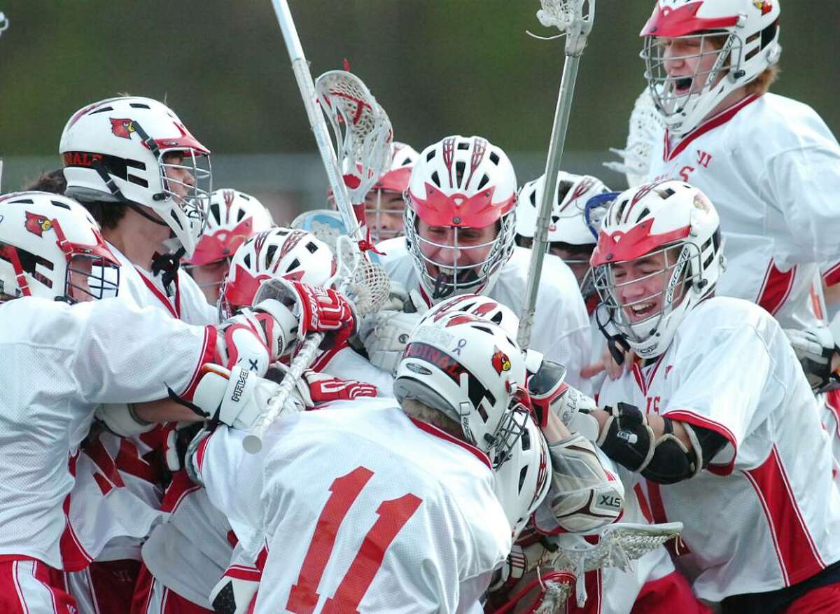 Pete Cabrera, # 11 of Greenwich High School, center, leads the celebration, as he and his teammates mob Greenwich High School freshman, Alex Moeser, who scored the winning goal in overtime against Wilton High School for an 11-10 victory, at GHS, Tuesday, April 13, 2010.