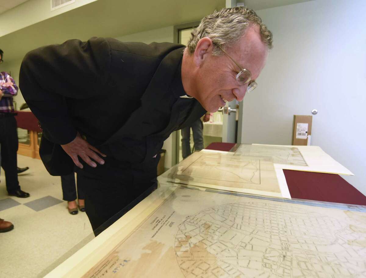 Father David Garcia examines a circular map of the city of San Antonio dating back to 1911 during the Tricentennial Commission's History and Education Subcommittee tour of the Municipal Archives and Records Facility on Friday, April 8, 2016.