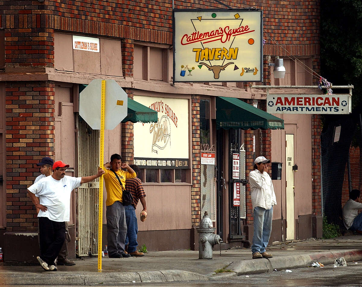 Migrant workers wait outside the Cattleman's Square Tavern for potential employers to stop and hire them. photo bob owen