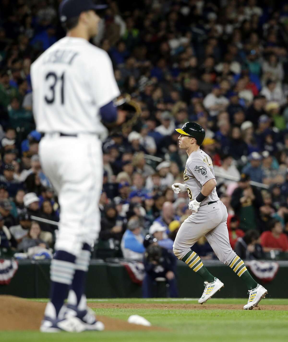 Seattle Mariners relief pitcher Steve Cishek waits as Oakland Athletics' Chris Coghlan rounds the bases on his home run during the ninth inning of a baseball game Friday, April 8, 2016, in Seattle. (AP Photo/Elaine Thompson)