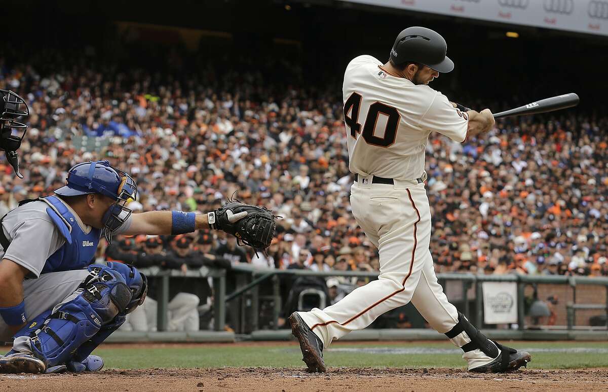 San Francisco Giants' Madison Bumgarner (40) hits a solo home run in front of Los Angeles Dodgers catcher A.J. Ellis during the second inning of a baseball game in San Francisco, Saturday, April 9, 2016. (AP Photo/Jeff Chiu)