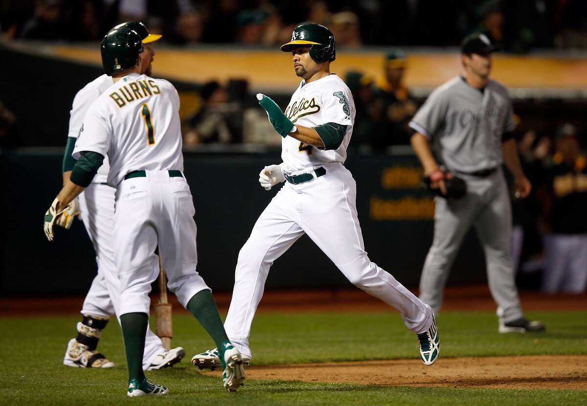 OAKLAND, CA - MAY 15: Coco Crisp #4 of the Oakland Athletics is congratulated by Billy Burns #1 after they all both scored on a triple by Josh Reddick #22 in the fourth inning of their game against the Chicago White Sox at O.co Coliseum on May 15, 2015 in Oakland, California. (Photo by Ezra Shaw/Getty Images)