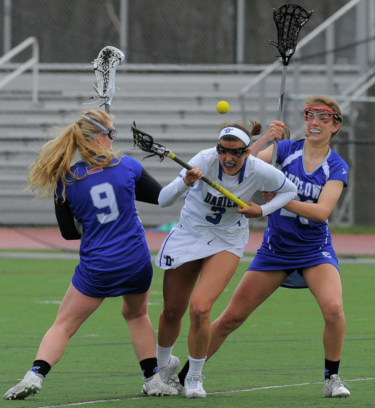 Darien’s Emma Lesko, center, fights to recover a loose ball between Ludlowe’s Paige Wilkman, left, and Amanda Schramm (21) during the first half Thursday in Darien.