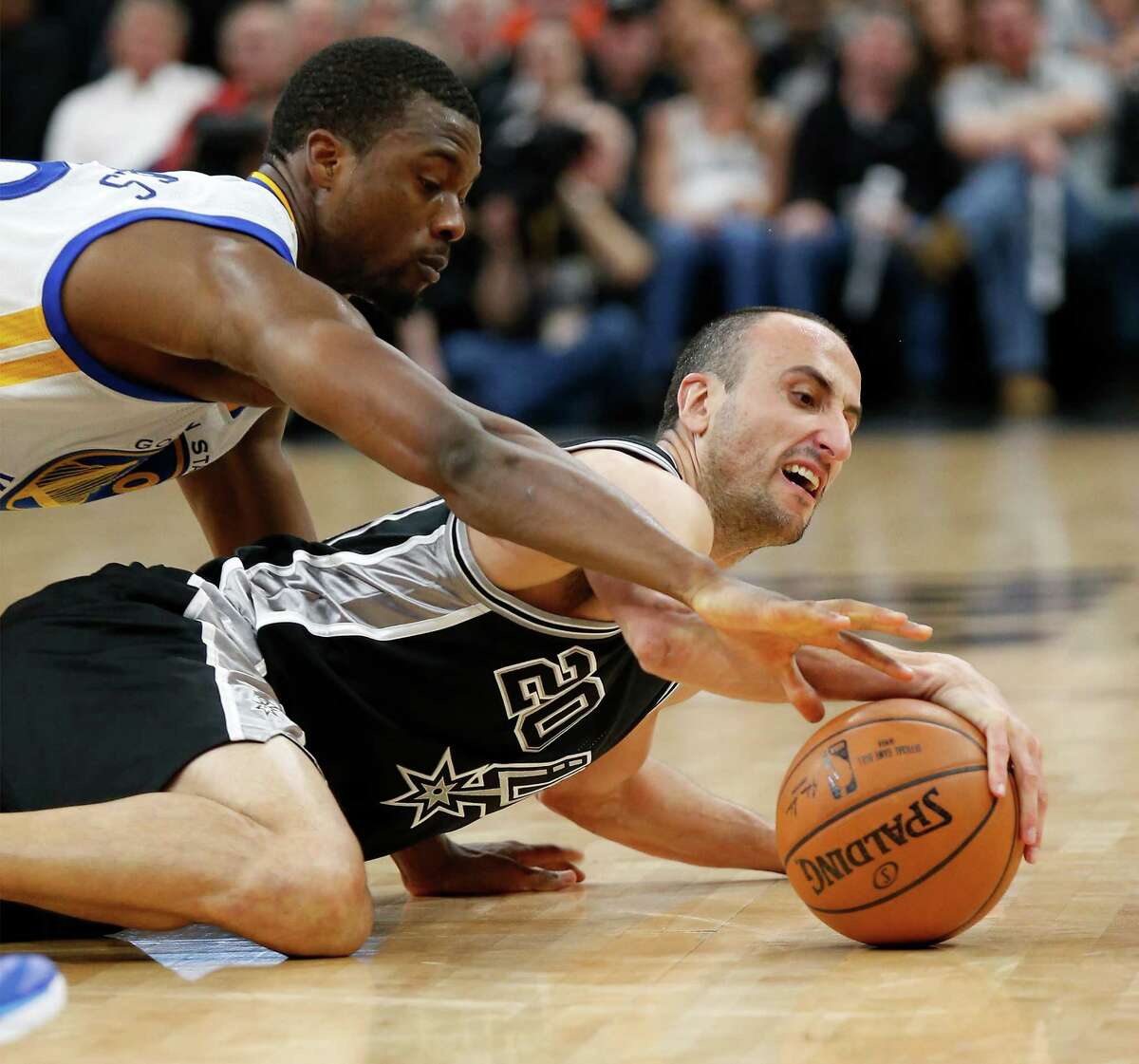 Spurs' Manu Ginobili (20) struggles to keep possession of loose ball against Golden State Warriors' Harrison Barnes (40) at the AT&T Center on Sunday, Apr. 10, 2016.