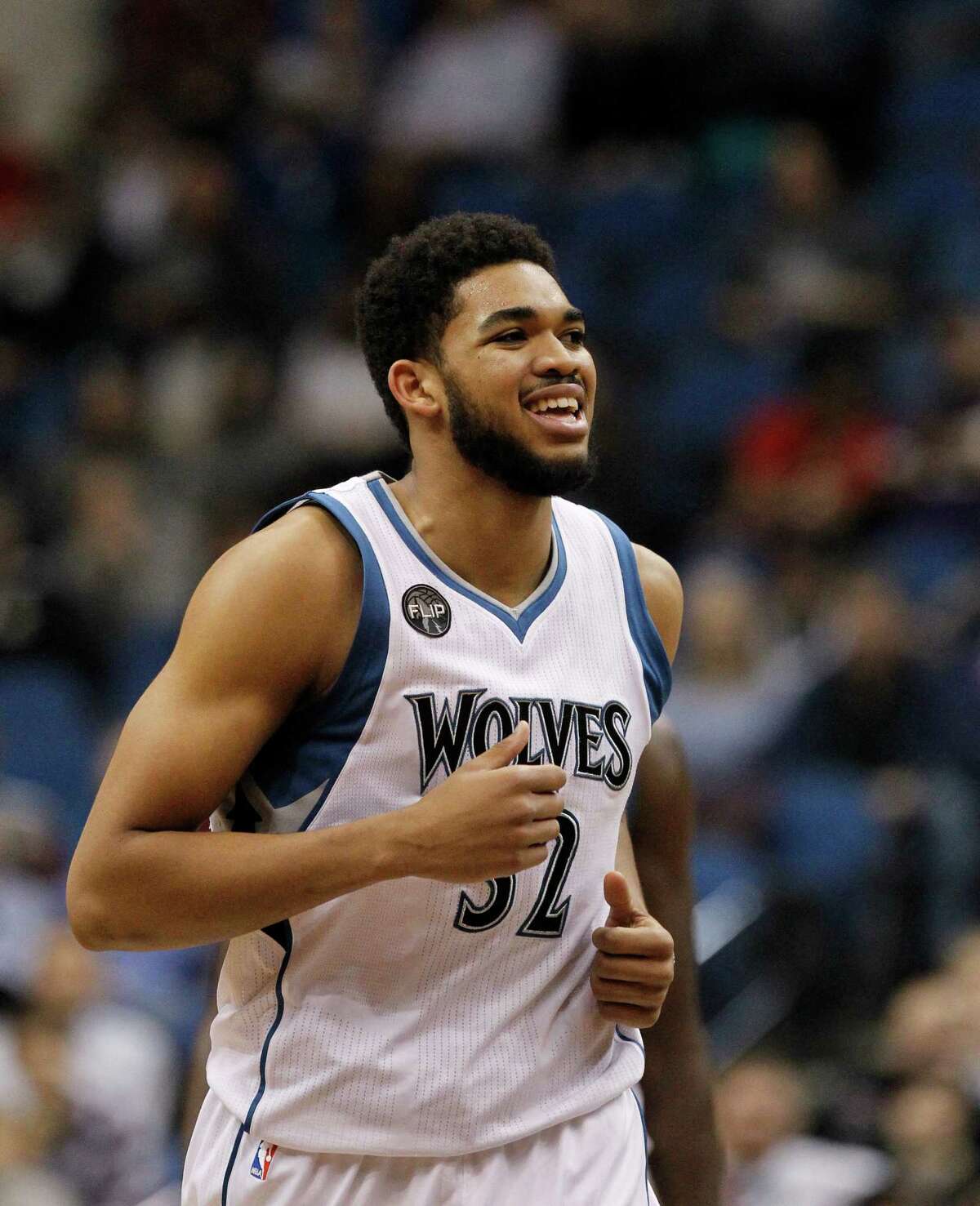 Minnesota Timberwolves center Karl-Anthony Towns (32) smiles during the second half of an NBA basketball game against the Houston Rockets in Minneapolis, Monday, April 11, 2016. The Rockets won 129-105.