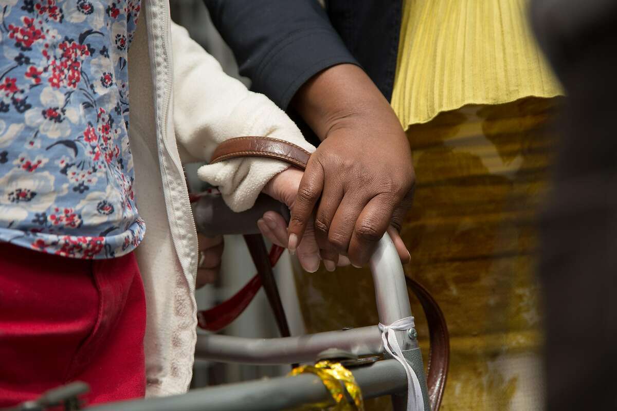 Iris Canada, left, and her niece, Iris, hold hands during a news conference on Tuesday, April 12, 2016 in San Francisco, Calif. Supporters of Canada, a 99-year-old woman who faces eviction from her Western Addition apartment, rallied and held a news conference outside the Superior Court of California. Canada has lived in her apartment for decades.