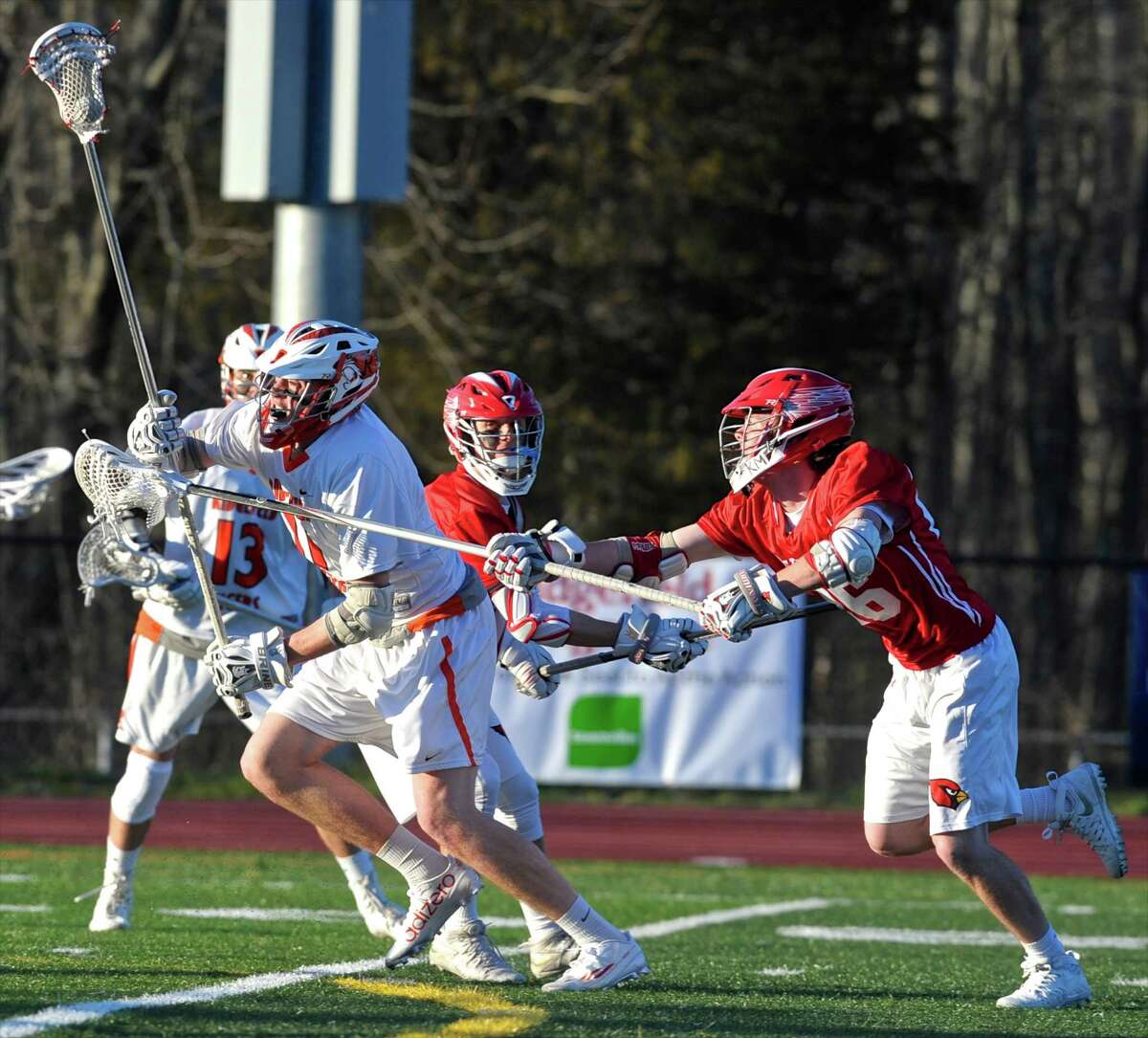 Ridgefield's Chase Levesque (11) moves in to score a goal while being defended by Greenwich's Daniel Colligan (26) in boys lacrosse game between Greenwich and Ridgefield high schools on Tuesday, April 12, 2016, at Ridgefield High School, in Ridgefield, Conn.