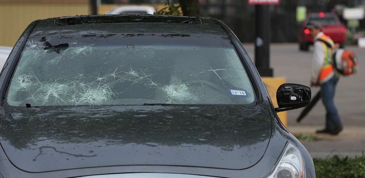 A car damaged by hail is in a Helotes area parking lot after a storm swept through the area last night.
