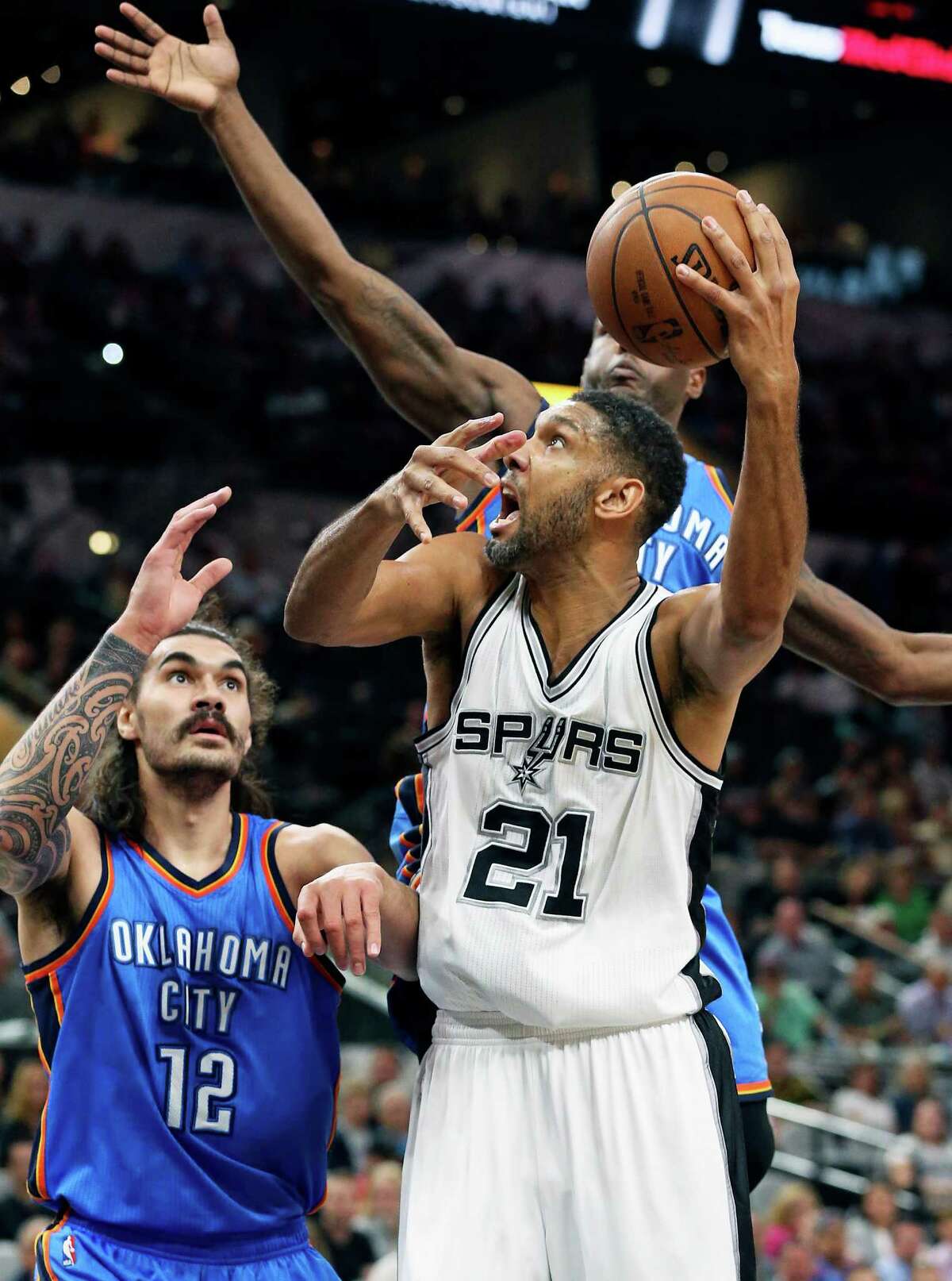 Tim Duncan gets off a shot in front of Steven Adams as the Spurs host Oklahoma at the AT&T Center on April 12, 2016.