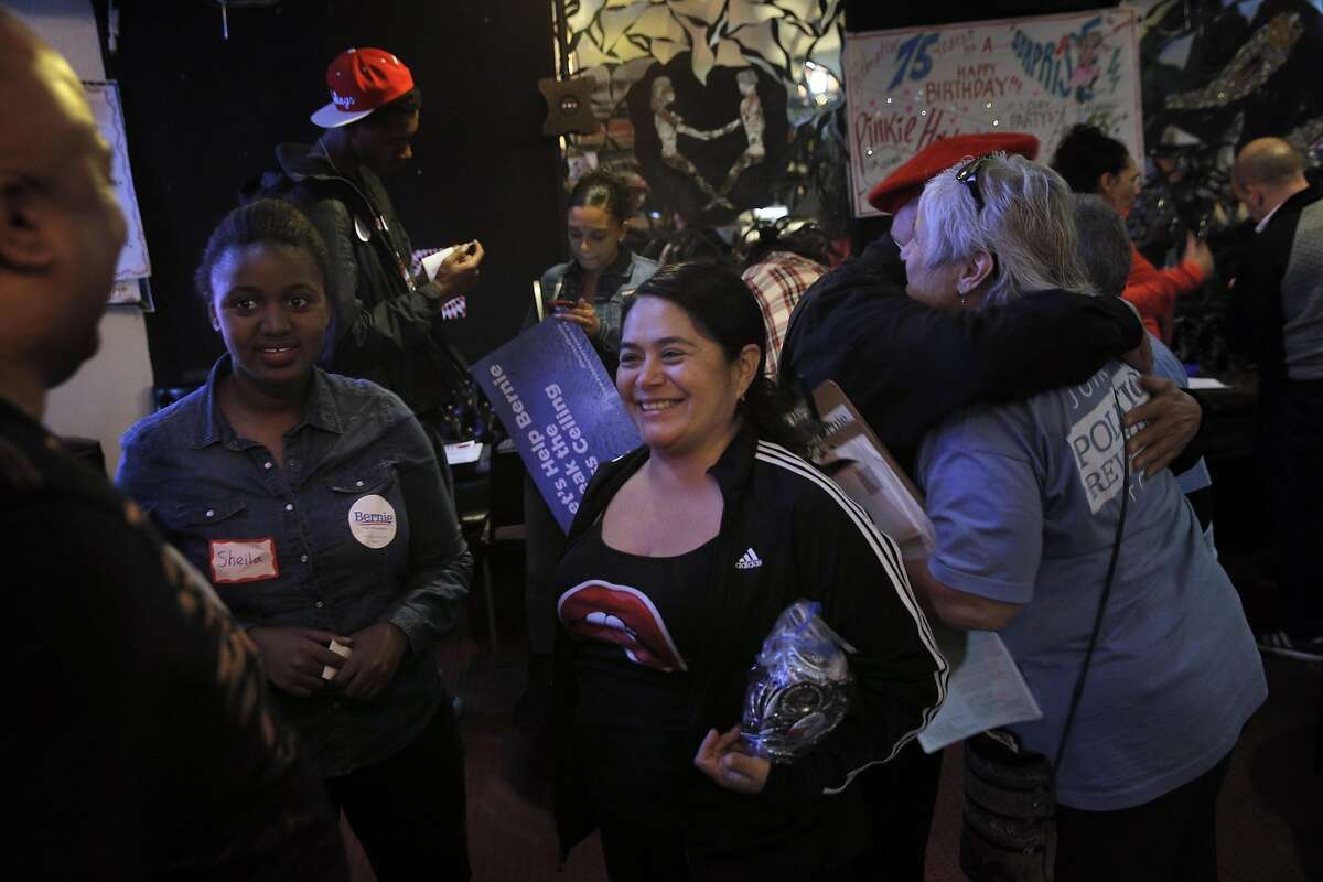 Adelita Gonzales, center, head coordinator for the People of Color Outreach for Bernie, chats with Dr. Terence Candell, left, during a Bernie Sanders Barnstorm organizing meeting at Sports Page Bar in Oakland, Calif., on Monday, April 11, 2016.