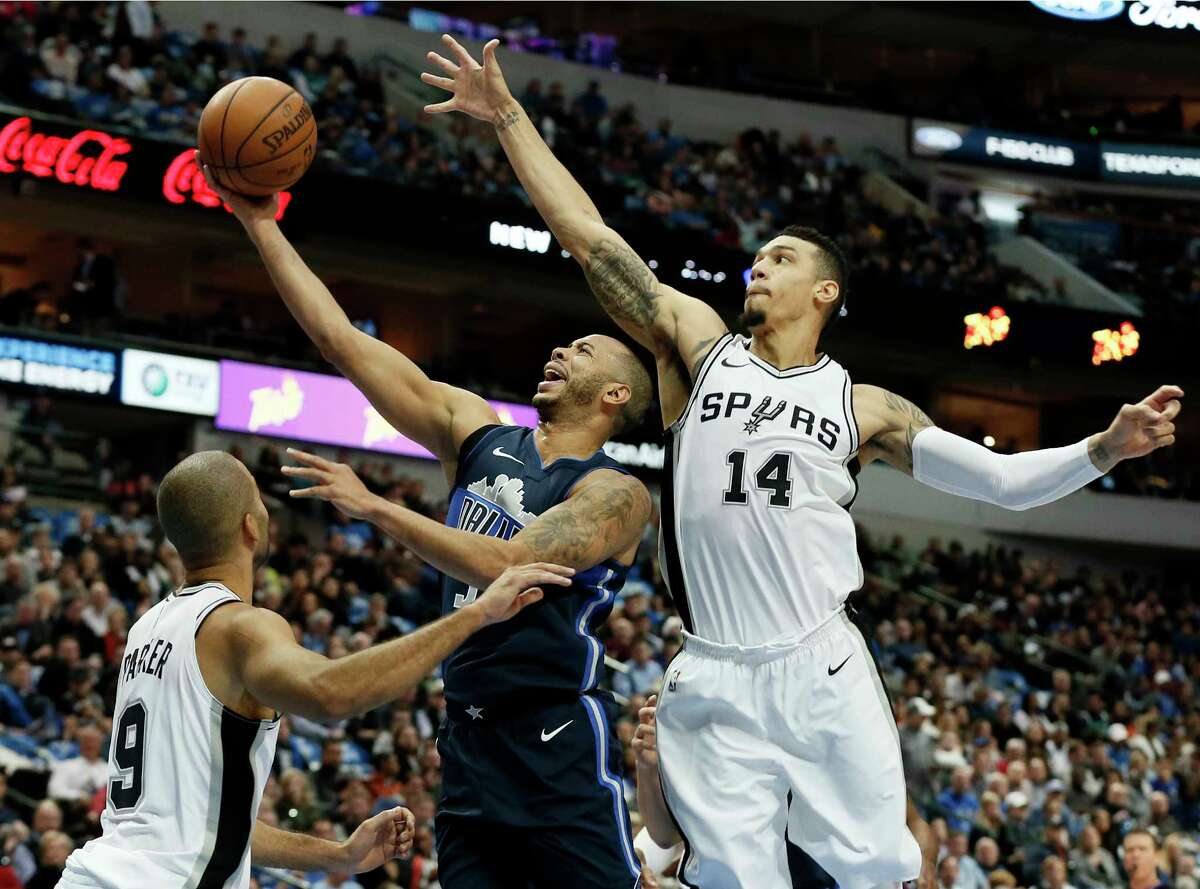 San Antonio Spurs guard Tony Parker , left, of France and Danny Green, right, defend as Dallas Mavericks' Devin Harris, center, goes up for a shot in the first half of an NBA basketball game,Tuesday, Dec. 12, 2017, in Dallas. (AP Photo/Tony Gutierrez)