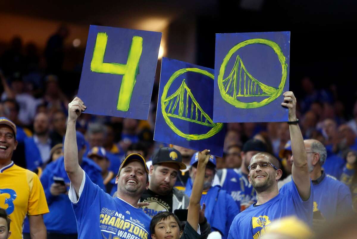 Golden State Warriors' fans celebrate Stephen Curry's 400th 3-pointer of the season in 3rd quarter against Memphis Grizzlies during NBA game at Oracle Arena in Oakland, Calif., on Wednesday, April 13, 2016.