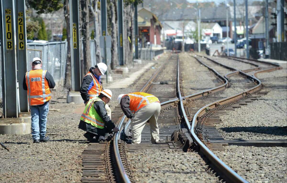 Investigators look at a section of track in the New Canaan rail yard, south of the New Canaan train station on Thursday, April 14. Service on Metro-North's New Canaan Branch is being affected by a "minor derailment" of a non-passenger train. One car on the derailed train, which had been removed, partially block the track leading to station.