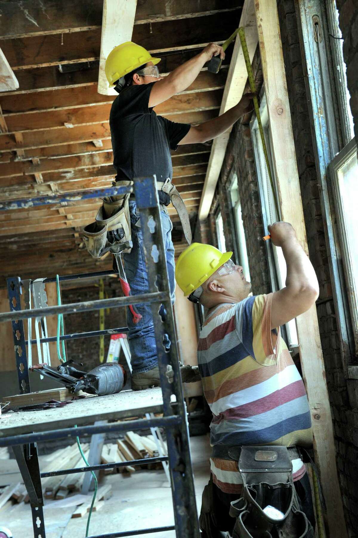 Manuel Guzman, left, and Marcelo Moura work on the inside space of the Pershing Building . The Pershing Building at the corner of Main and West Streets in Danbury is being fitted for Naugatuck Valley Community College’s new downtown campus.