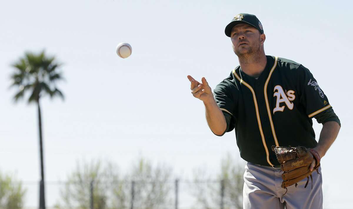 Oakland Athletics relief pitcher Ryan Madson works on a drill during spring training baseball practice in Mesa, Ariz., Sunday, Feb. 21, 2016. (AP Photo/Chris Carlson)