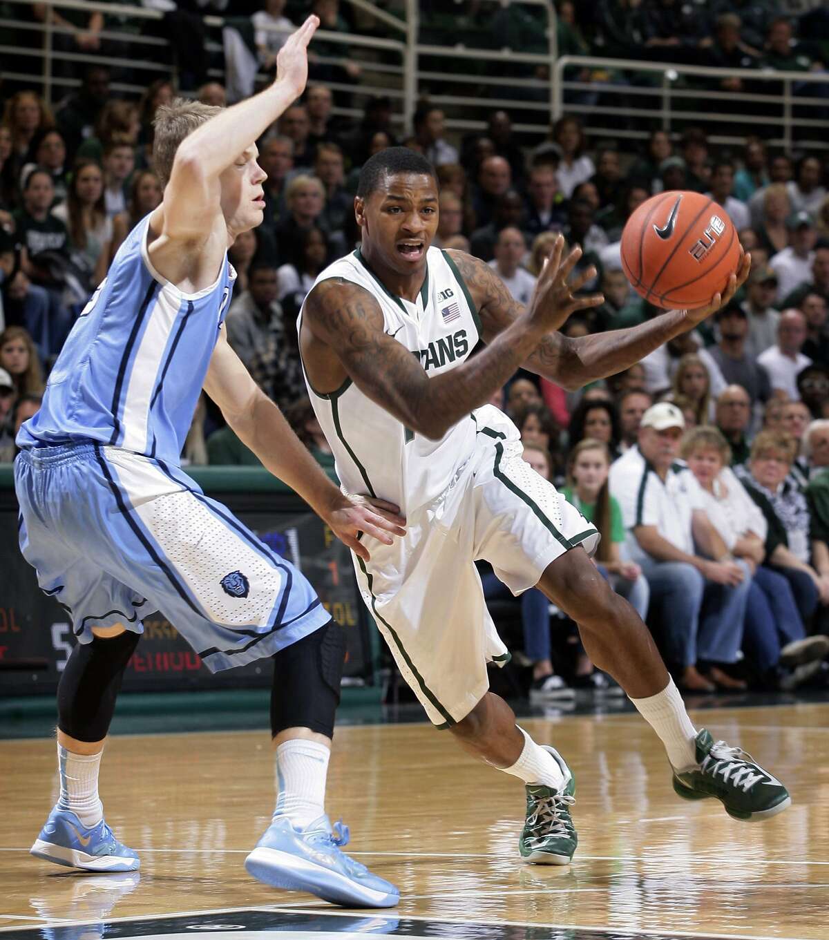 Michigan State's Keith Appling, right, drives against Columbia's Grant Mullins during the first half of an NCAA college basketball game Friday, Nov. 15, 2013, in East Lansing, Mich. (AP Photo/Al Goldis)