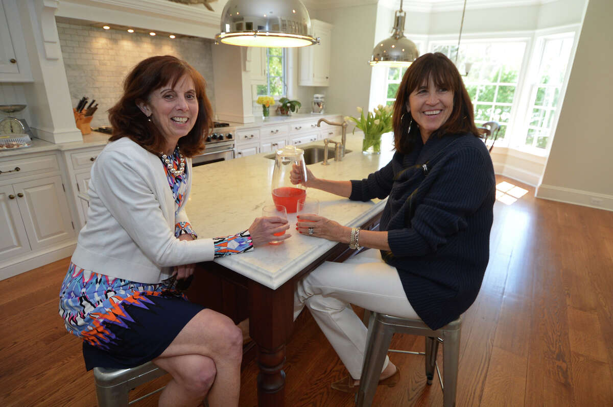 Halstead Property's Elmerina Brooks and Ashley O'Neil enjoy a cold drink in the chefs kitchen after the open house at 2 Harbor Bluff in Rowayton, Conn. on Thursday, April, 14, 2016. The property designed by renowned architect Louise Brooks, is for sale.