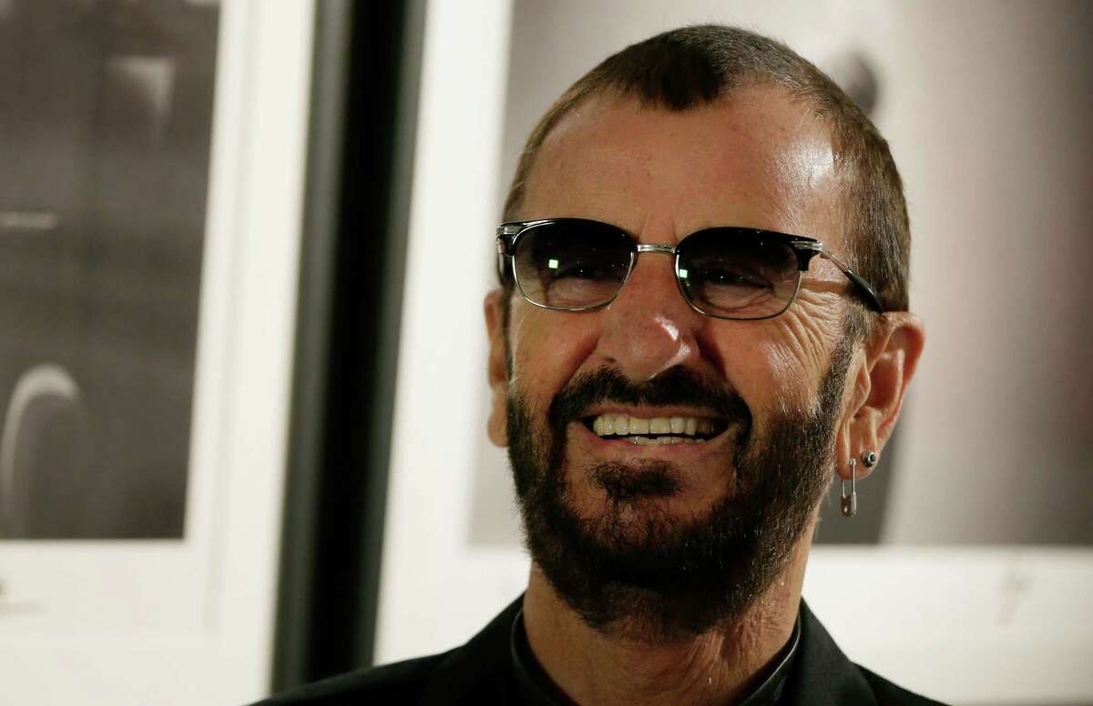 Pop icon and former Beatle Ringo Starr poses for the media in front of some of his photographs during a photocall as he launches a book called "Photograph" in London, Wednesday, Sept. 9, 2015. The book contains photographs by Starr from his childhood, the Beatles and beyond. (AP Photo/Alastair Grant)
