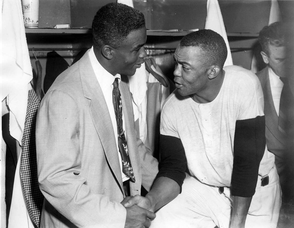 Jackie Robinson chats with Monte Irvin of the Giants.