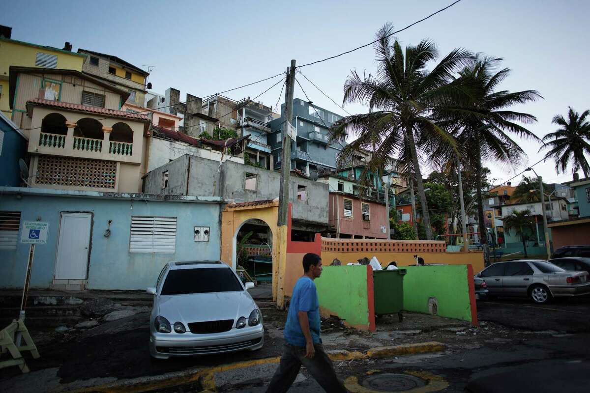 Pedestrians walk through La Perla, an informal settlement in Old San Juan, Puerto Rico. Skeptical lawmakers at the House Natural Resources Committee heard testimony last week on a plan to rescue Puerto Rico from its giant debt defaults, as witnesses warned that only quick action by Congress could keep a bad situation from becoming a lost decade.