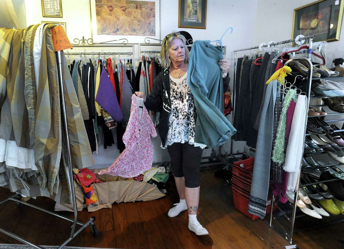 Deb Pennywell, of New Milford, a volunteer at Healing The Children Thrift, sorts through clothes Thursday, April 14, 2016. The thrift shop at 27 East Street in New Milford is closing Saturday.